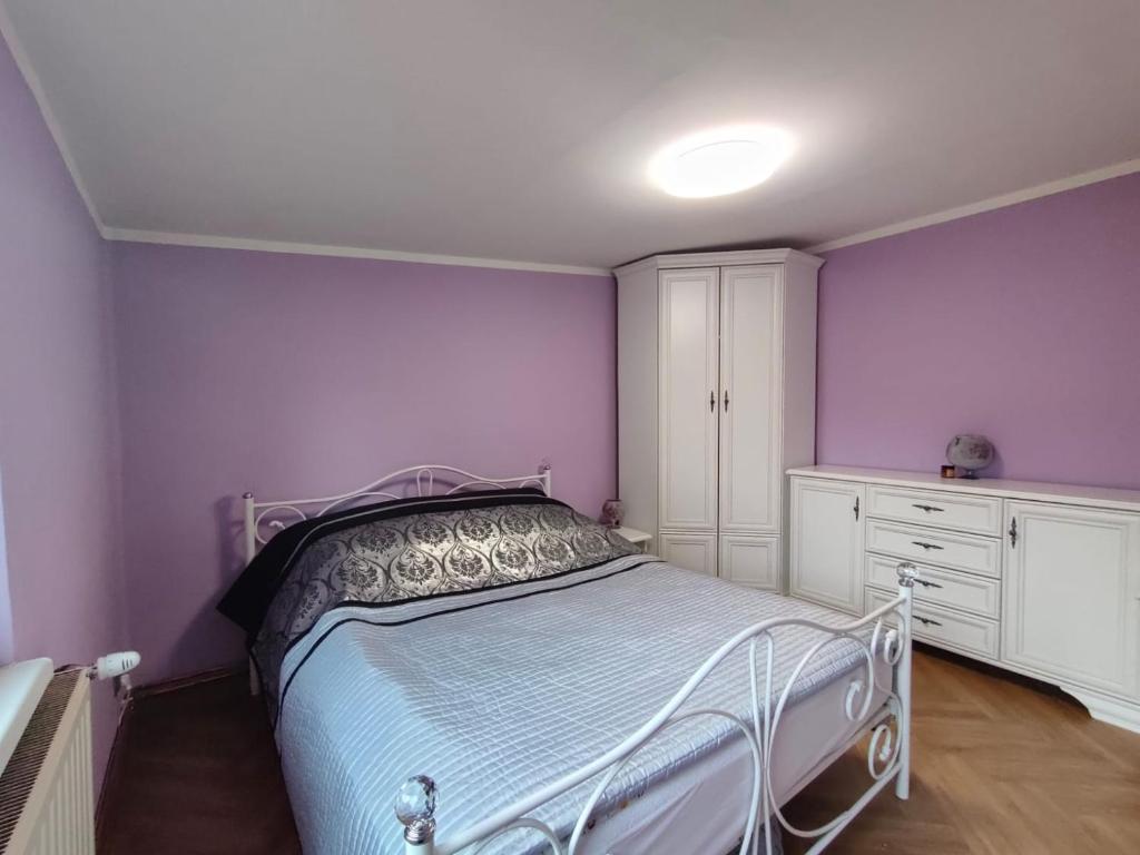 Apartament Centrum 2 Ustroń — lawendowa sypialnia z podwójnym łóżkiem i szafą