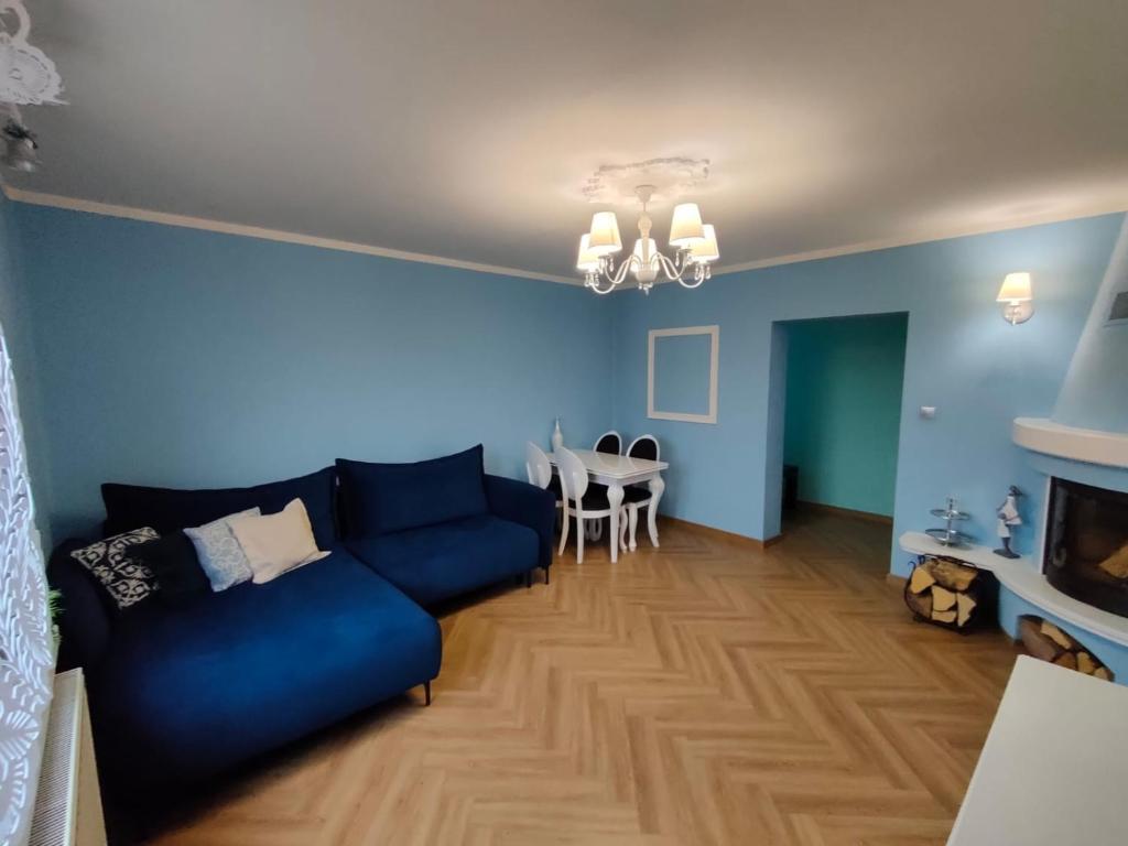 Apartament Centrum 2 Ustroń — niebieski salon z granatową sofą i jadalnią