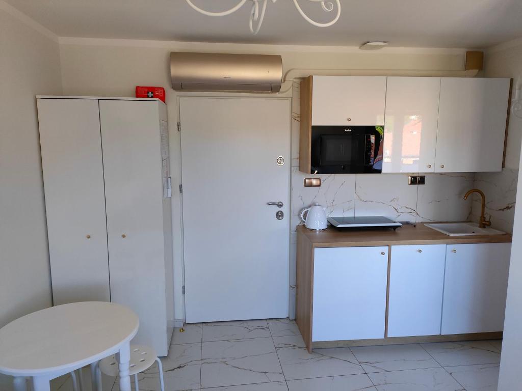Apartament Centrum Ustroń — biały aneks kuchenny z płytą, mikrofalą i czajnikiem