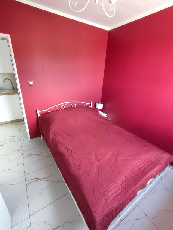 Apartament Centrum Ustroń — podwójne łóżko w bordowej sypialni